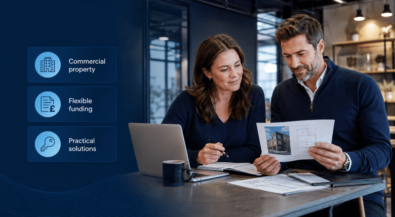 Commercial Finance in Practice with a white business couple reviewing commercial property funding documents in a branded blue office setting