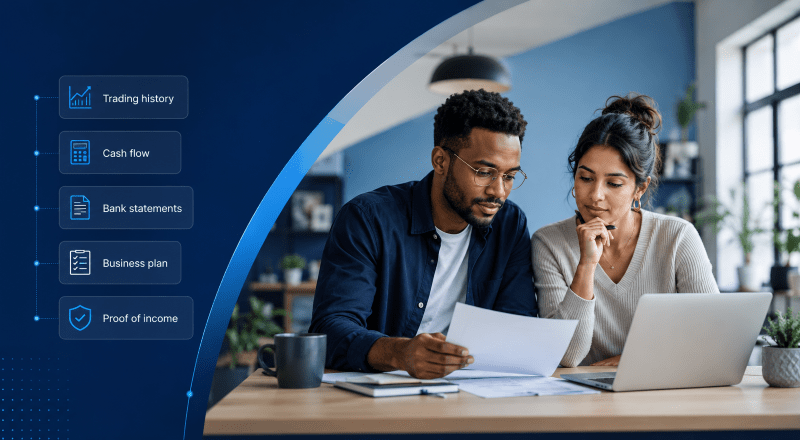 Business Loan Requirements: young mixed couple reviewing documents and a laptop, with icons showing trading history, cash flow, bank statements, business plan and proof of income.