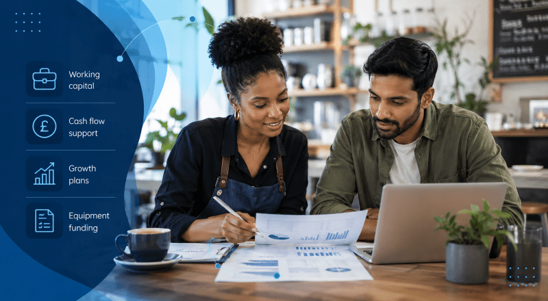 What Is a Business Loan? Young mixed couple reviewing business finance documents and laptop with icons showing working capital, cash flow support, growth plans and equipment funding.