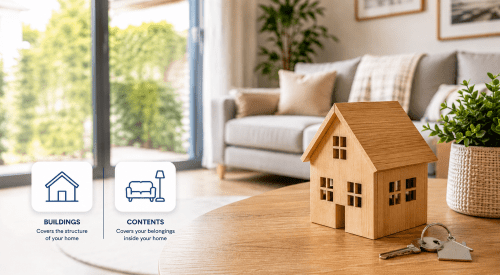Buildings and contents insurance hero image showing a wooden house model, keys, and branded icons for home and contents cover in a modern living room.