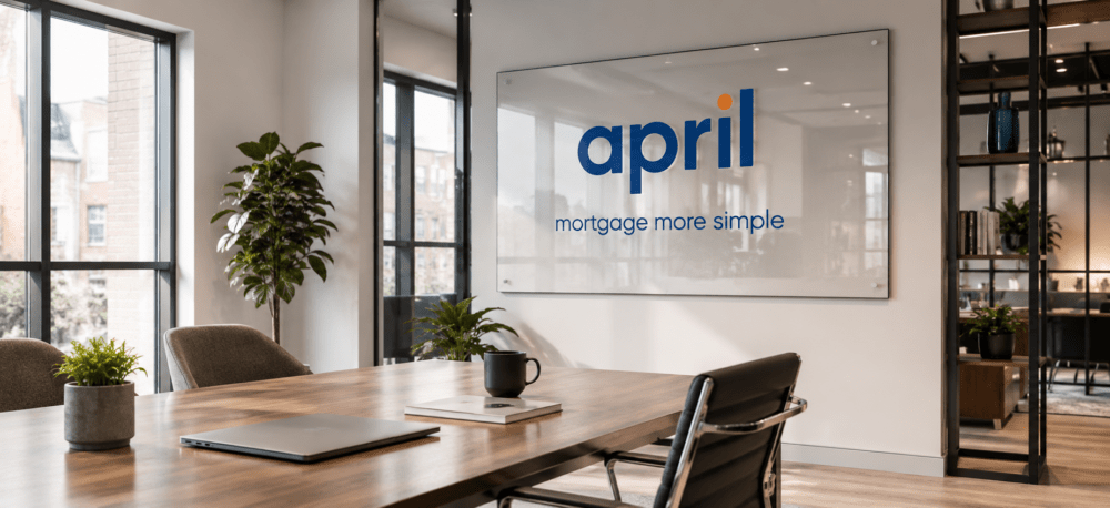Further Borrowing hero image showing a modern office meeting room with April branding displayed on a large glass sign on the back wall.