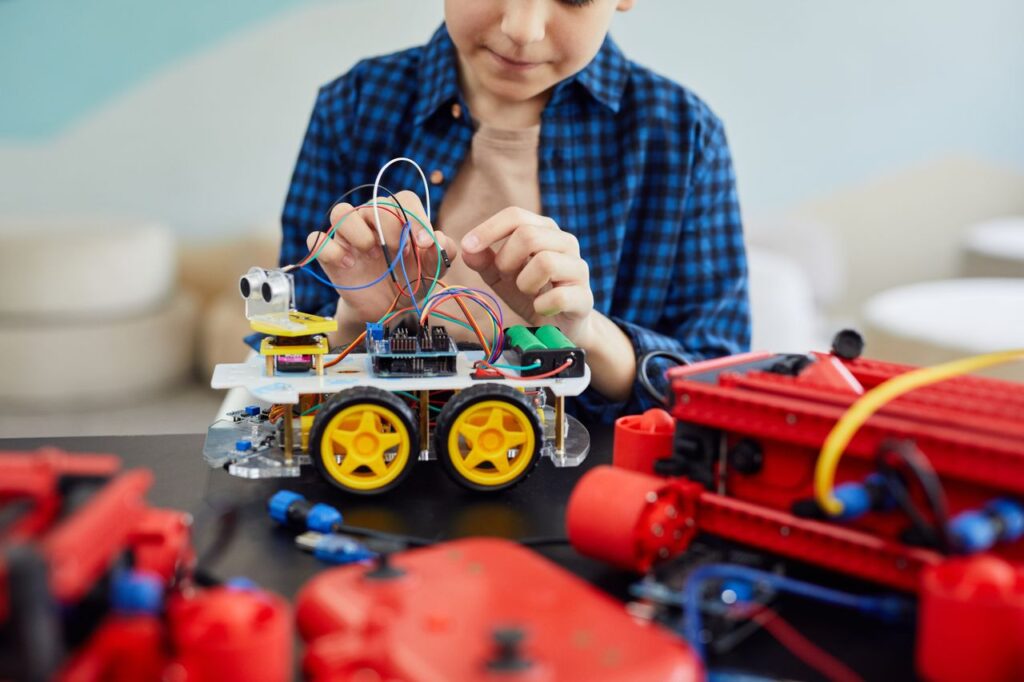 Child building a robotics project, representing education finance supporting school fees, learning opportunities and educational development.